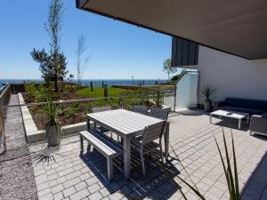 una mesa y un banco en un patio con vistas al océano en Sea Breeze, en Bournemouth