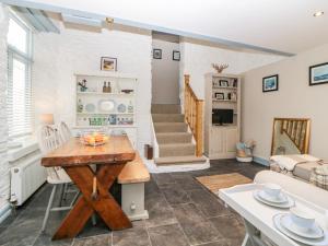a kitchen and living room with a table and chairs at The Old Dairy in Torpoint