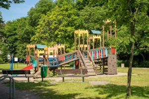 a playground in a park with a slide at Apartamenty Fenomen - Baltic, Nadmorskie Tarasy, FREE PARKING, SWIMMING POOL, SAUNA AND OTHER! in Kołobrzeg