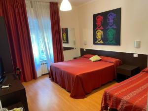 a hotel room with two beds and a television at Hotel Stazione del Sole in Albenga