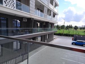 a balcony of a building with a blue car in a parking lot at Jeni's studio in Constanţa