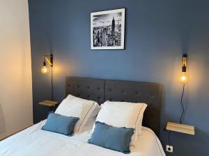 Un dormitorio con una cama con dos almohadas azules. en Family Appart 2, en Le Tréport