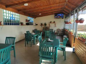 a dining room with green tables and chairs at Vila Alexia in Corbu
