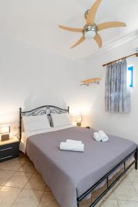 a bedroom with a bed and a ceiling fan at Anthia Apartment Sea View in Kato Zakros