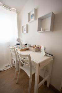 a white dining room table with white chairs at EXCLUSIVE ROOMS in Scalea