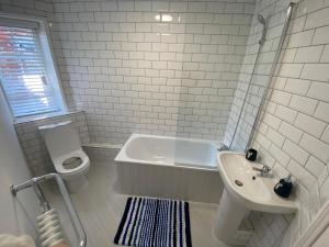 a bathroom with a tub and a toilet and a sink at Oyster Catchers in Ryde