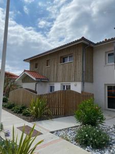 a house with a wooden fence in front of it at Residence Plage Oceane in Biscarrosse-Plage