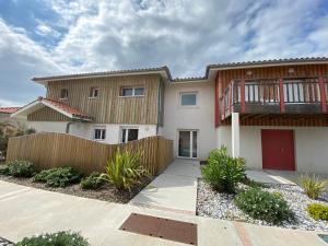 a house with a wooden fence in front of it at Residence Plage Oceane in Biscarrosse-Plage