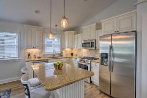 a kitchen with white cabinets and a stainless steel refrigerator at Port Clinton Home with Lake Views! in Port Clinton