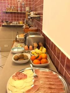 a counter with plates of food and fruit on it at Hotel Chopin in Genoa