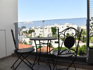a table and chairs on a balcony with a view of a city at BAZ TOWER in Nicosia
