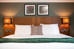 The Oatlands Chaser by Innkeeper's Collection في يبريدج: غرفة نوم بسرير مع صورتين على الحائط