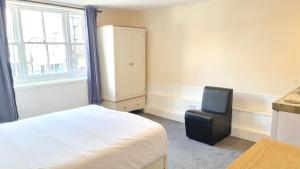 a bedroom with a bed and a chair and a window at Grace Apartments - Living Rock in Ashford