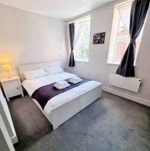 a bedroom with a white bed with two towels on it at Modern Maisonette 2 Bedrooms Newly Renovated in Bournemouth