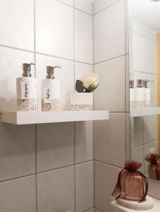 ein Bad mit weiß gefliesten Wänden und Regalen mit Pflegeprodukten in der Unterkunft Haus Christine in Mieders