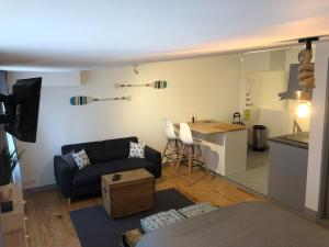 a living room with a couch and a kitchen at Le "Duo Sètois" in Sète