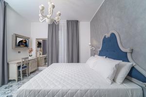 a bedroom with a blue and white bed and a desk at The Gentleman of Tropea in Tropea