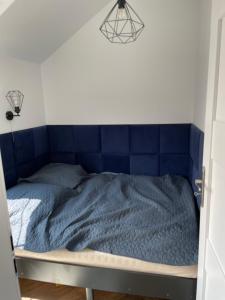 Cama en habitación con edredón azul en Prestige Apartment Old Town Zamość en Zamość