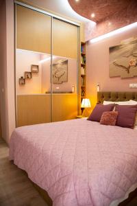 1 dormitorio con 1 cama grande con manta morada en Athens Nautical Flat, en Pireo