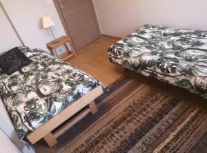 1 dormitorio con 2 camas, alfombra y mesa en Appartement meublé tout confort en Scionzier