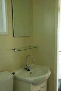 a bathroom with a sink and a mirror and a toilet at Minicamping De Visser in Zoutelande +66 photos