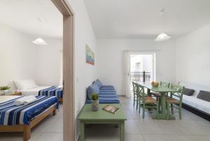 Cette chambre comprend un lit, une table et un canapé. dans l'établissement Olive Grove Apartments, à Elounda