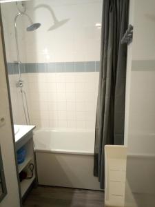 ein Badezimmer mit einer weißen Badewanne und einer Dusche in der Unterkunft Appart terrasse Superdevoluy in Le Dévoluy