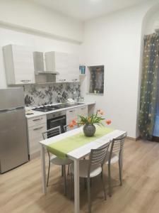 a kitchen with a table and chairs and a kitchen with a stove at Casetta Bevilacqua in Sciacca
