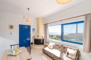 a living room with a couch and a table and a window at Anthia Apartment Sea View in Kato Zakros