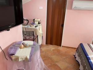 a living room with a table and a tv at Centro estivo Il Piccolo Paradiso in Sonnino