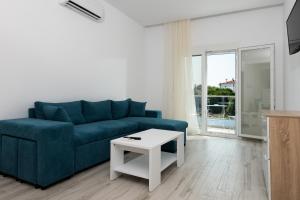 a living room with a blue couch and a table at Diamanti Apartments Downtown Limenas Thasos in Limenas