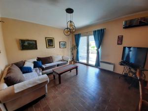 ein Wohnzimmer mit einem Sofa und einem TV in der Unterkunft Holiday Home Panorama House in Herceg-Novi