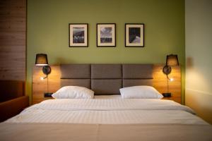 a bedroom with a large white bed with two lamps at Pensiunea La Bella Vista in Poiana Negrii