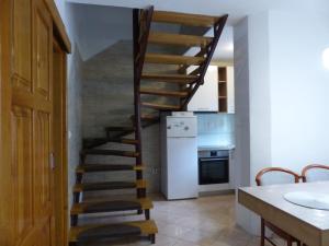 a wooden spiral staircase in a kitchen with a refrigerator at House Plitvice in Plitvička Jezera