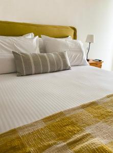 a large bed with white sheets and pillows on it at Villa Evi in Ammouliani