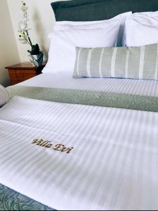 un letto bianco con la parola "aiuto di seta" scritta sopra di Villa Evi ad Ammouliani