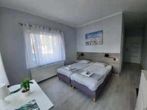 a bedroom with a bed and a table in it at Villa Międzyzdroje in Międzyzdroje