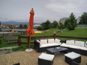 a patio with couches and an umbrella and a park at Na Hrázi in Český Krumlov