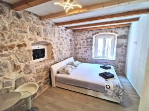 a bedroom with a bed and a stone wall at Nanna's little paradise in Hvar