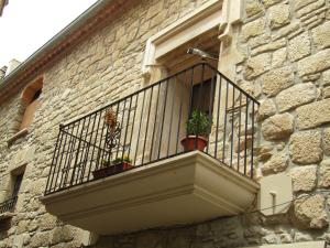 un balcone con piante in vaso su un edificio in pietra di Cal Belló Casa rural a Lleida