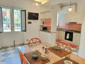 una cucina e una sala da pranzo con tavolo e sedie di Mara House a Levanto