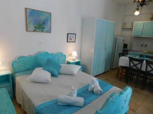una camera con un letto blu e due sedie blu di Yacht Front Studio - Back Yard - No 7 a Ios Chora