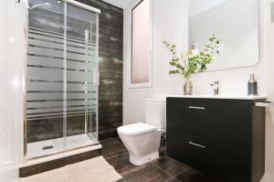 a bathroom with a toilet and a glass shower at New flat in the center-Eixample Passeig de Gracia in Barcelona +43 photos