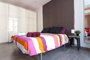 a bedroom with a large bed with a colorful blanket at New flat in the center-Eixample Passeig de Gracia in Barcelona