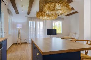a kitchen with a table and a chandelier at Dekalo Seaside Villa, Kriopigi in Kriopigi