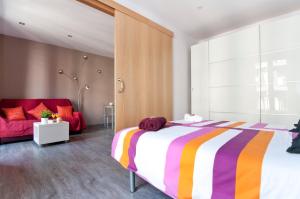 バルセロナにあるNew flat in the center-Eixample Passeig de Graciaのベッドルーム(大型ベッド1台、赤いソファ付)