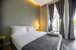 a bedroom with a large white bed and a window at The Hygge Lisbon Suites - Estrela in Lisbon