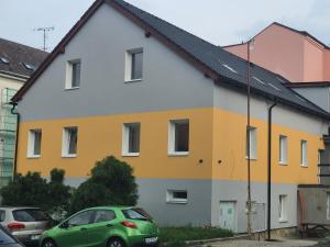 una casa colorida con autos estacionados frente a ella en Apartmány HAVLÍČKOVA s parkováním zdarma en Česká Lípa
