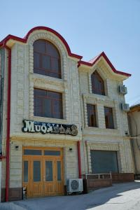 un edificio con un cartel en la parte delantera en Hotel Muqaddas, en Samarkand