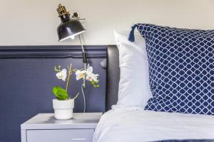 a bed with a lamp and a plant on a night stand at Realm choice estates in Catford